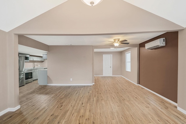 unfurnished living room featuring a wall unit AC, ceiling fan, light hardwood / wood-style flooring, and sink