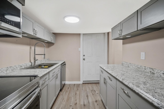 kitchen featuring gray cabinets, light hardwood / wood-style floors, sink, and appliances with stainless steel finishes