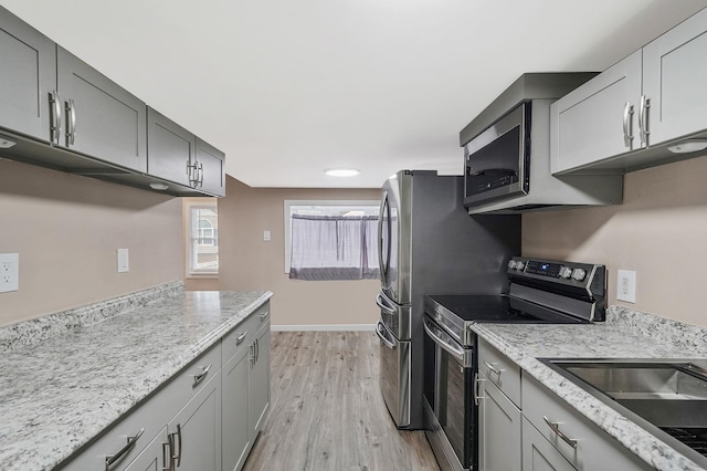 kitchen featuring electric stove, light stone counters, light hardwood / wood-style flooring, and gray cabinetry