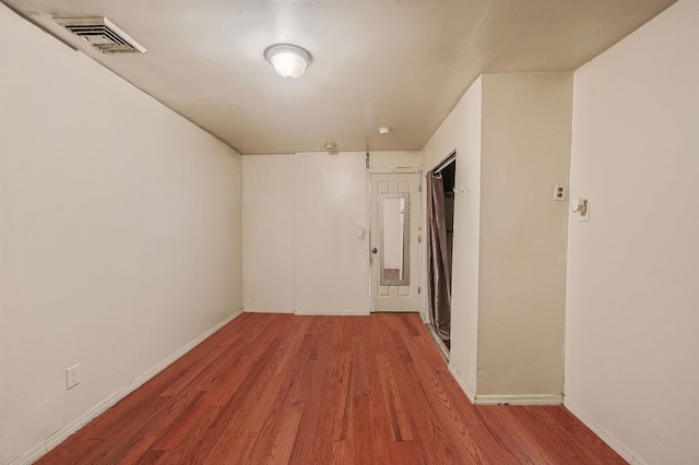 hallway with hardwood / wood-style floors