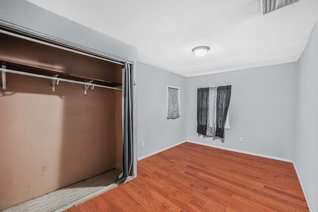 unfurnished bedroom with hardwood / wood-style flooring and a closet