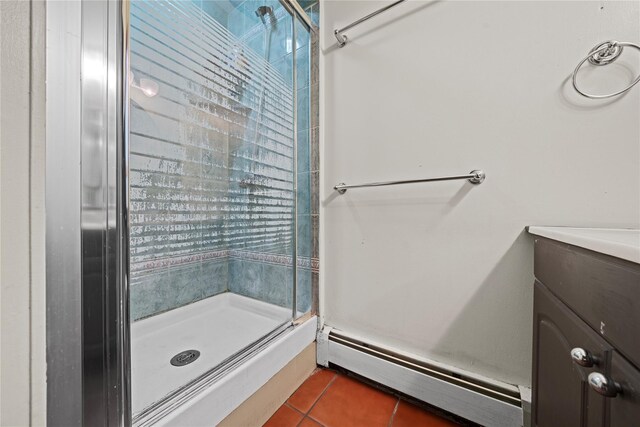 bathroom featuring baseboard heating, tile patterned flooring, vanity, and an enclosed shower