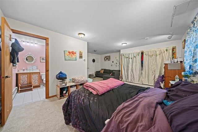 bedroom with light carpet and a baseboard heating unit