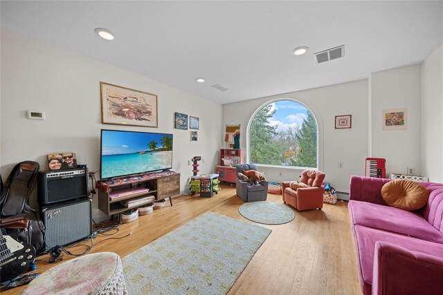 living room with wood-type flooring and a baseboard radiator