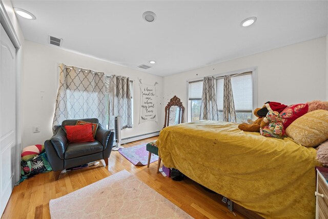 bedroom with hardwood / wood-style flooring and a baseboard radiator