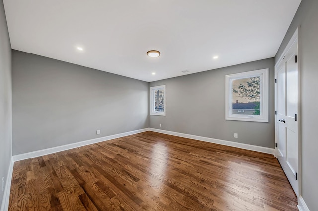 spare room featuring hardwood / wood-style flooring and a healthy amount of sunlight