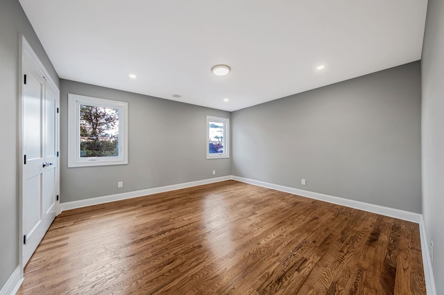 empty room featuring a wealth of natural light and hardwood / wood-style floors