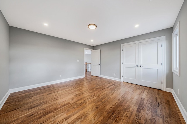 unfurnished bedroom with hardwood / wood-style flooring and a closet