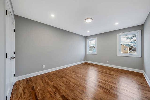 unfurnished room with hardwood / wood-style flooring