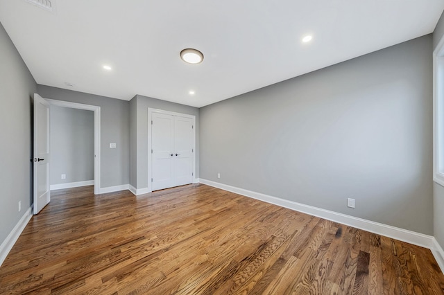 unfurnished bedroom featuring hardwood / wood-style floors and a closet