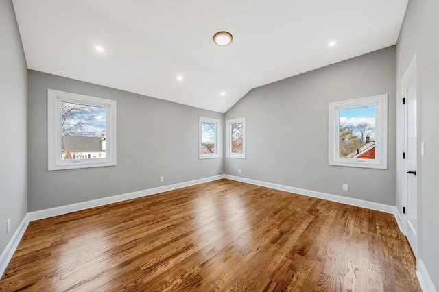 unfurnished room featuring hardwood / wood-style floors and lofted ceiling