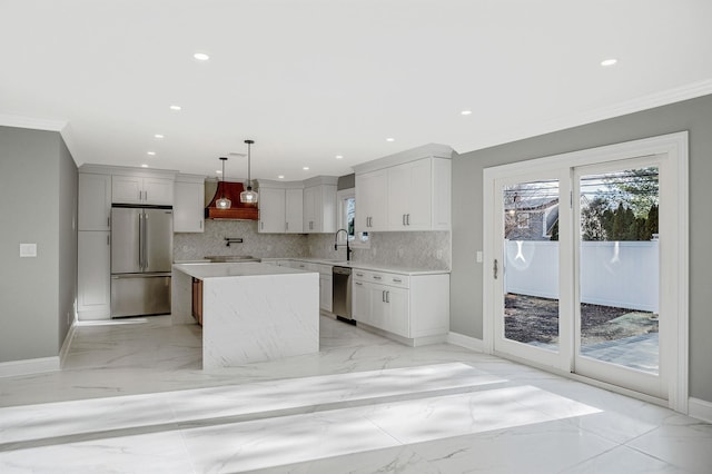 kitchen featuring pendant lighting, white cabinets, appliances with stainless steel finishes, tasteful backsplash, and a kitchen island