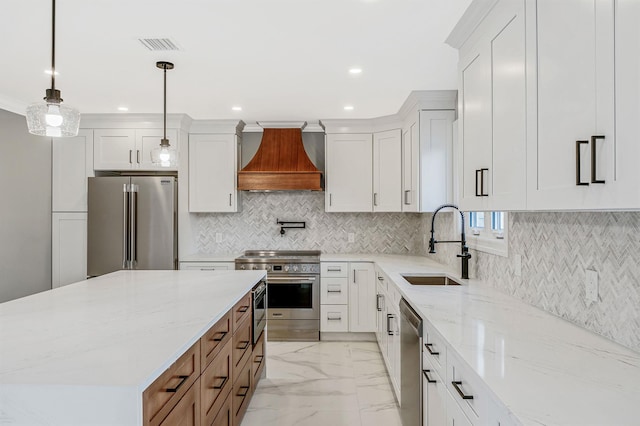 kitchen featuring stainless steel appliances, light stone counters, decorative light fixtures, white cabinets, and custom range hood