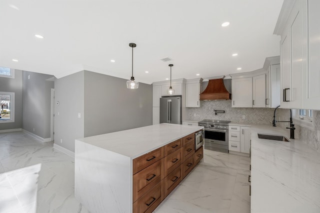 kitchen with custom exhaust hood, decorative light fixtures, a kitchen island, white cabinetry, and stainless steel appliances