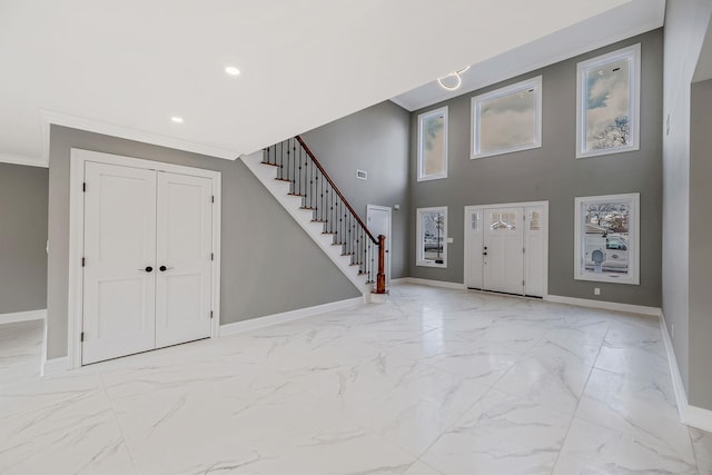 foyer entrance featuring crown molding and a high ceiling