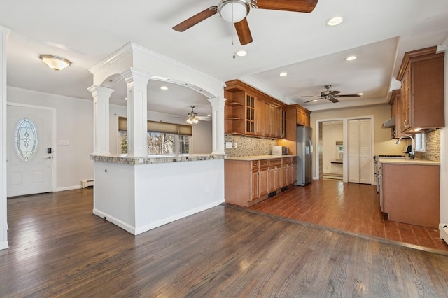 kitchen with a baseboard radiator, dark wood finished floors, decorative columns, stainless steel refrigerator with ice dispenser, and brown cabinets