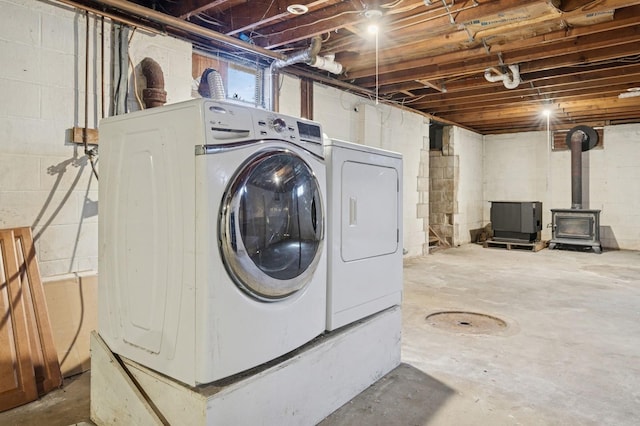 laundry area with washer and clothes dryer, laundry area, and a wood stove