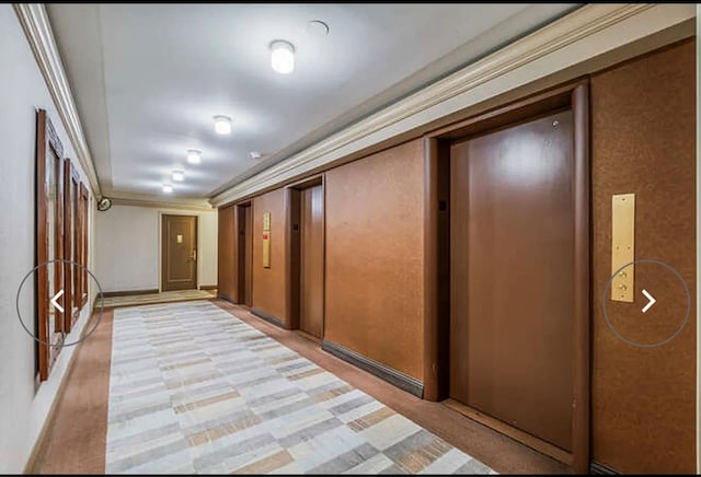 hallway with crown molding and elevator