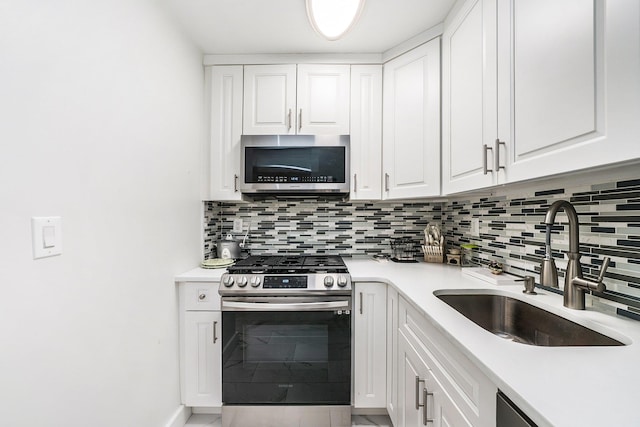 kitchen with backsplash, white cabinetry, sink, and appliances with stainless steel finishes