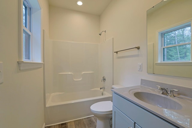 full bathroom with shower / bathing tub combination, vanity, hardwood / wood-style flooring, and toilet