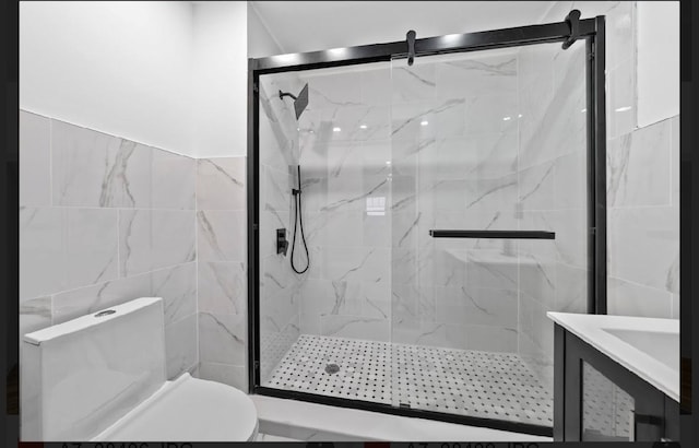 bathroom with vanity, toilet, a shower with door, and tile walls