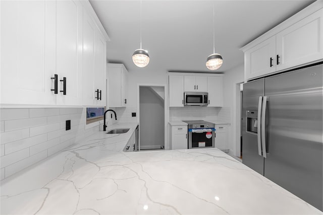 kitchen featuring backsplash, sink, hanging light fixtures, light stone countertops, and stainless steel appliances