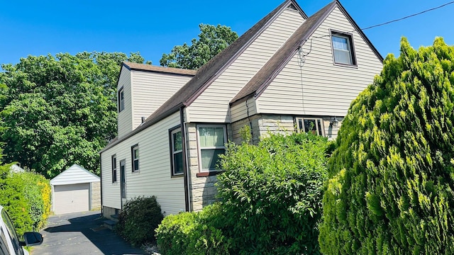 view of home's exterior featuring a garage and an outbuilding