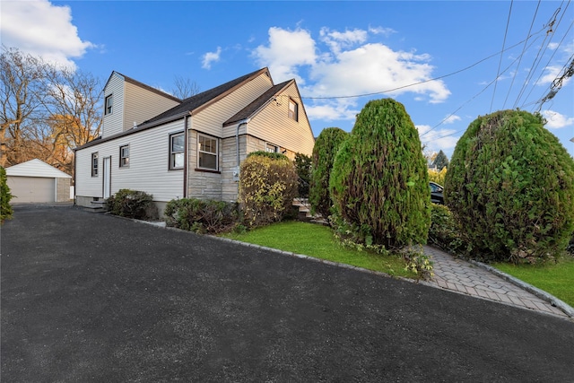 view of property exterior with a garage and an outdoor structure