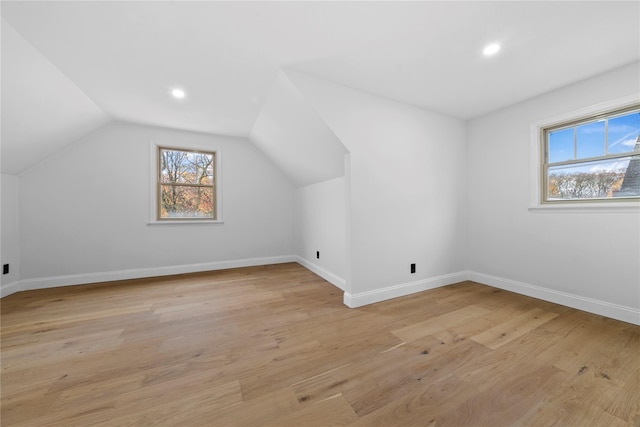 bonus room with light hardwood / wood-style floors and vaulted ceiling