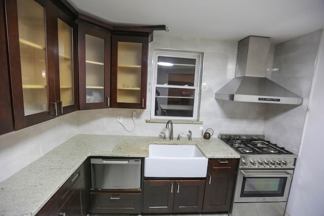 kitchen featuring light stone countertops, sink, wall chimney exhaust hood, backsplash, and high end range