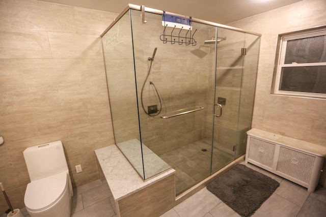 bathroom with tile patterned floors, toilet, tile walls, an enclosed shower, and radiator heating unit