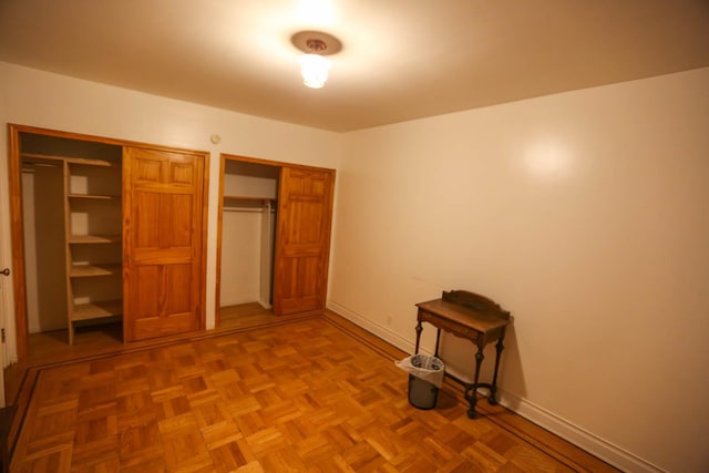 unfurnished bedroom with parquet floors and a closet