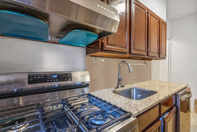 kitchen featuring backsplash, range hood, sink, light stone countertops, and stainless steel appliances