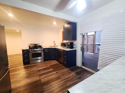 kitchen with ceiling fan, dark wood-type flooring, sink, and stainless steel appliances