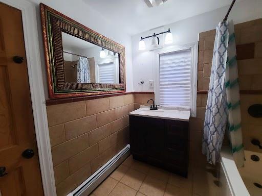 bathroom with tile walls, tile patterned floors, vanity, and shower / bathtub combination with curtain