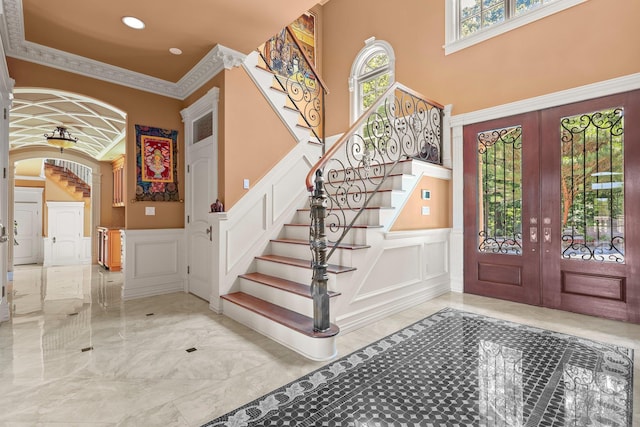 foyer featuring french doors and ornamental molding