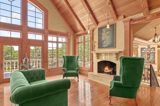 interior space with beam ceiling, wooden ceiling, high vaulted ceiling, light hardwood / wood-style floors, and a fireplace