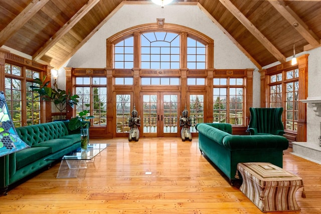 living room featuring french doors, light hardwood / wood-style floors, high vaulted ceiling, and beam ceiling