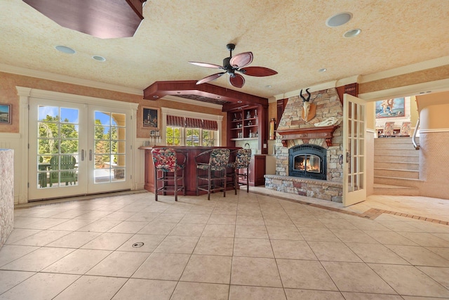 unfurnished living room featuring tile patterned flooring, french doors, a textured ceiling, and ceiling fan