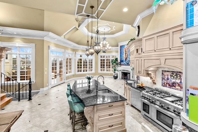 kitchen featuring decorative backsplash, a kitchen breakfast bar, dark stone counters, sink, and range with two ovens