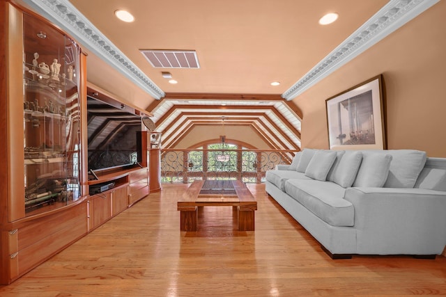 living room featuring light hardwood / wood-style flooring, vaulted ceiling, and ornamental molding