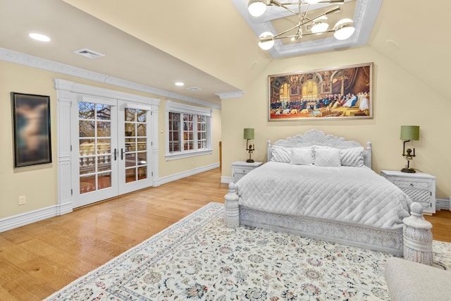 bedroom with access to exterior, french doors, hardwood / wood-style flooring, and vaulted ceiling