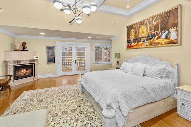 bedroom featuring french doors, light hardwood / wood-style flooring, and ornamental molding