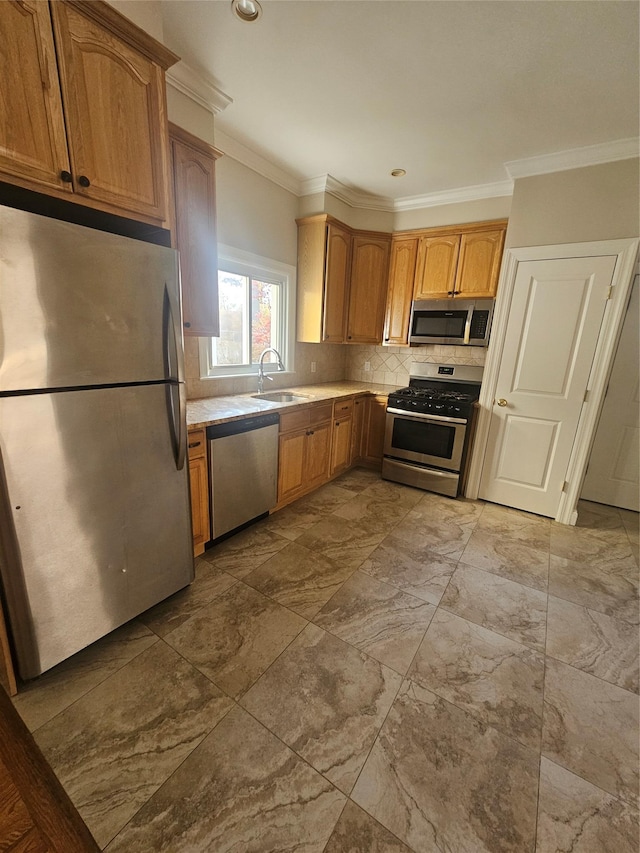 kitchen with backsplash, ornamental molding, sink, and appliances with stainless steel finishes