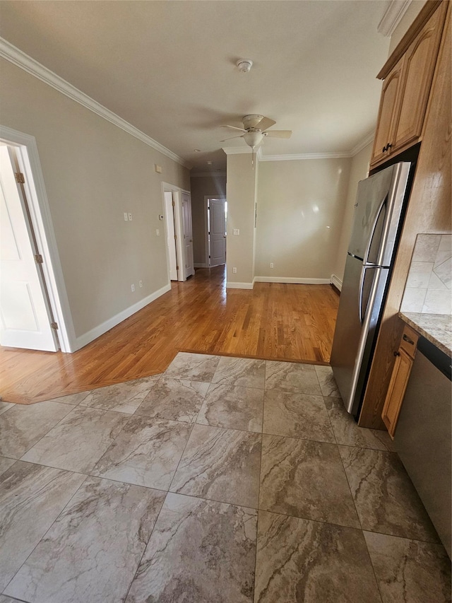 kitchen with ceiling fan, light wood-type flooring, ornamental molding, light stone counters, and stainless steel refrigerator