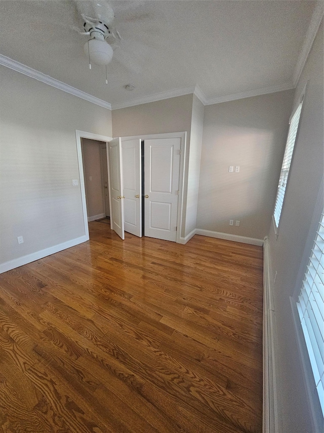 unfurnished bedroom with a textured ceiling, ceiling fan, wood-type flooring, and ornamental molding