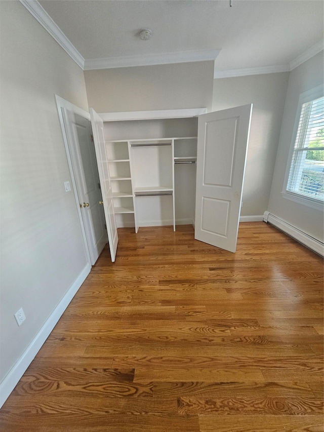 unfurnished bedroom with light wood-type flooring, a closet, baseboard heating, and ornamental molding