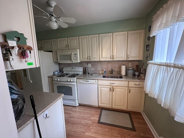 kitchen with light wood-type flooring, backsplash, white appliances, ceiling fan, and sink