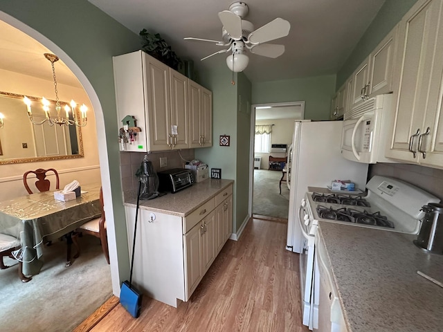 kitchen with light hardwood / wood-style flooring, ceiling fan with notable chandelier, pendant lighting, and white appliances