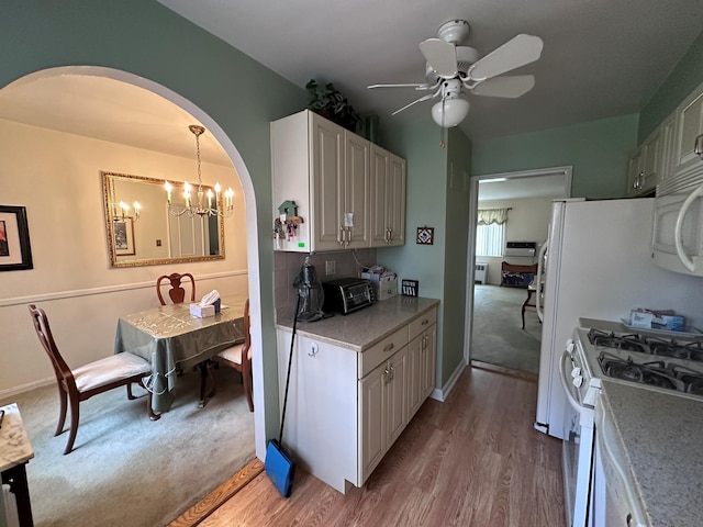 kitchen with white cabinetry, light hardwood / wood-style flooring, pendant lighting, white appliances, and ceiling fan with notable chandelier